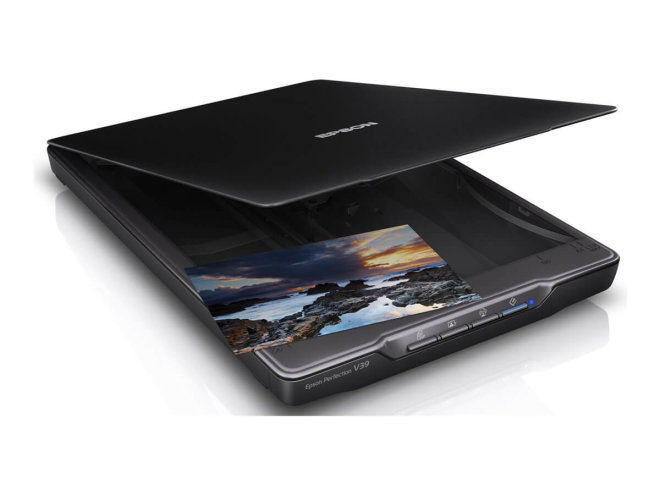 Copy electronic vam predstavlja Skener EPSON Perfection V39II Flatbed [B11B268401]: Na fotografii je skener koji je malo zakrenut u desnu stranu. Poklopac od skenera je otvoren pod kutom od 30stupnjeva.