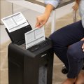 Copy electronic vam predstavlja Uništavač papira Fellowes AutoMax™ 80M, razina sigurnosti P-4, do 100 listova A4, rez 4x12 mm, kapacitet spremnika 17 l. Na fotografiji je crni uređaj koji je postavljen u ured. Pored uređaja sjedi ženska osoba koja sa jednom rukom drži isjeckani papir. Koš za papir je povuče ispred uređaja i pun je sjeckanog papira.