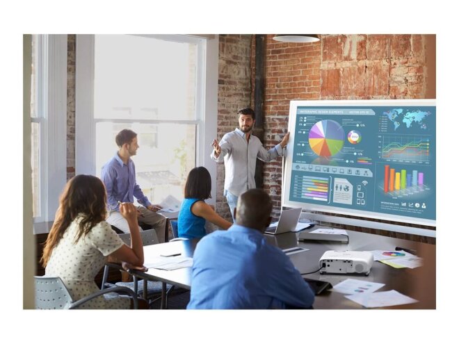 Copy electronic vam predstavlja Projektor EPSON EB-FH18 3LCD, 4100lm, Full HD, WiFi, Miracast [V11HB59240]. Na fotografiji je ured sa 5 djelatnika. Jedan je ispred platna i drži prezentaciju. Ispred njih je veliki sto na kojem se nalazi bijelu projektor.